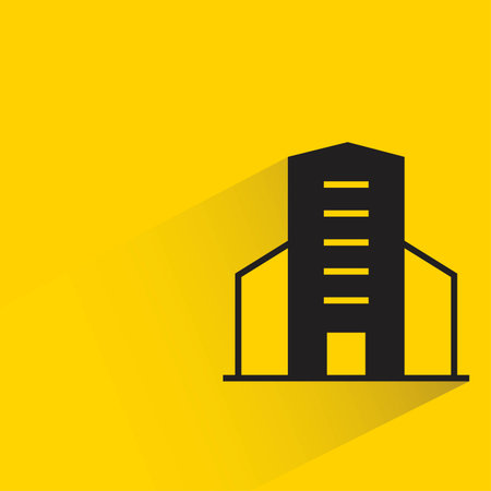 city tower building icon with shadow on yellow background, flat design, vector illustrationのイラスト素材