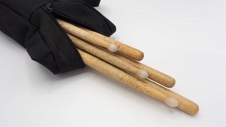 Drum sticks and black bags on white background.の写真素材