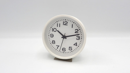 White clock with minute hand and hour hand on white background.の写真素材