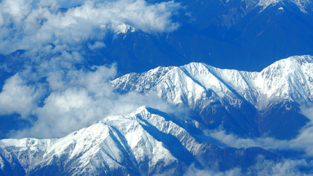 Top view of snow hills and clouds and blue sky.の写真素材
