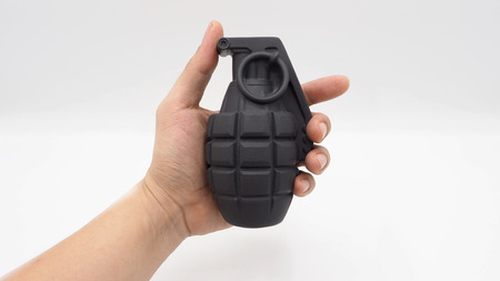 Man left hand and military bomb and white background.の写真素材