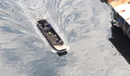 Small old long tailed boat and asia man and sailing in the small river.の写真素材