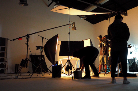 Silhouette of people working in production studio for shooting or recording by digital camera and lighting set.の写真素材