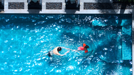 High angle view of swimming pool that father and daughter are playing together and have happiness...