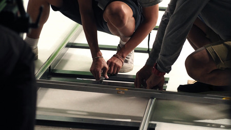 Behind the scenes of production team setting dolly track for camera equipment and video shooting in a big studio.の写真素材