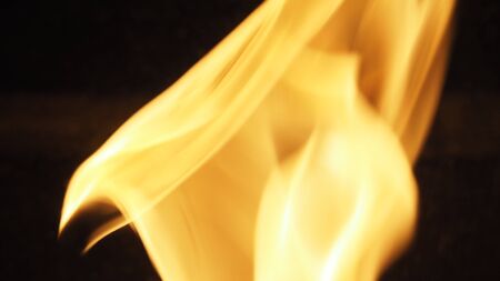 Fire for cooking is blazing dangerously close-up and yellow color on the black background.の写真素材