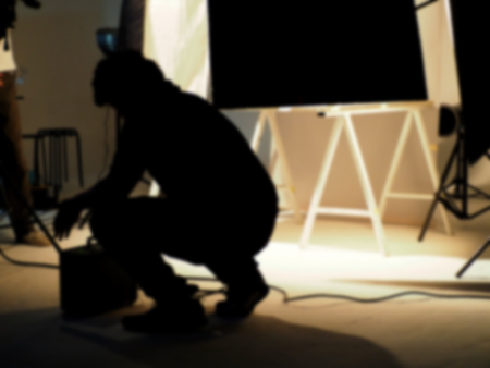 Blurry image behind the scenes of shooting video production in a studio with small set professional lighting equipment.の写真素材