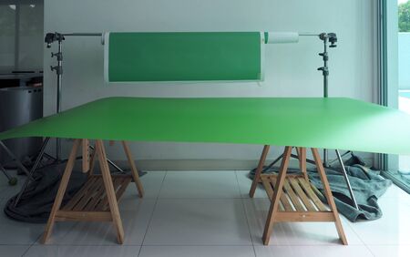 Green screen paper backdrop card board and tripod in home studio for chroma key video production.の写真素材