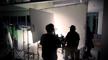 Behind the scene of film crew team are shooting video commercial production and silhouette camera...