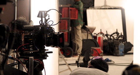 Behind the video shooting production crew team working and set of full hd camera equipment in studio.の写真素材