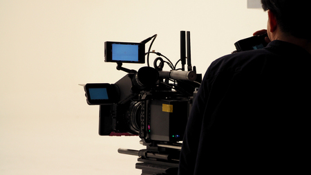 Behind the video shooting production crew team working and set of full hd camera equipment in...