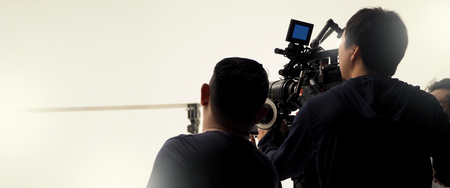 Behind the scenes of video camera shooting by film crew team production people in big studio for commercial works.の写真素材