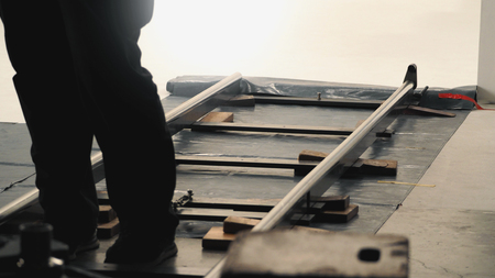 Behind the scenes of production team setting dolly track for video camera equipment before movie shooting in a big studio. の写真素材