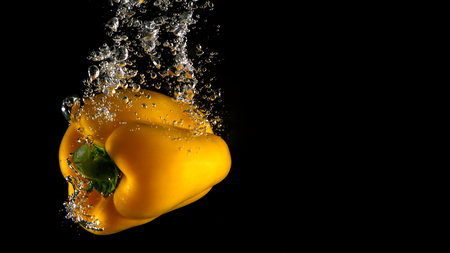 Colorful fresh vegetable cleaning by drop in to water splash and black background.の写真素材