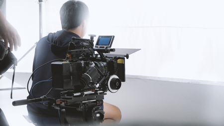Behind video camera that recording online commercial or web film movie in the big studio production with professional equipment such as high resolution cam and monitors and LED light with crew team setの写真素材