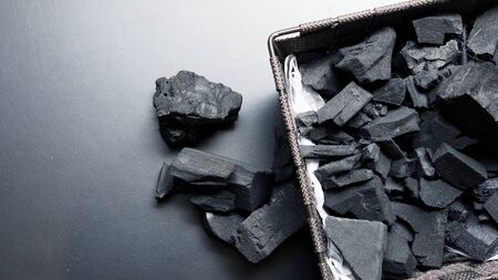 Close-up images of black color charcoal on black background that made from natural wood which represent energy power concept or healthy or use for absorb odor in the room or refrigerator.の写真素材