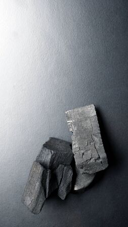 Close-up images of black color charcoal on black background that made from natural wood which represent energy power concept or healthy or use for absorb odor in the room or refrigerator.の写真素材