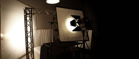 Silhoutte images of video production and lighting set for filming which movie crew team working and silhouette shadow of camera and professional equipment in big studio for commercial advertising.の写真素材