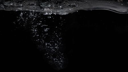 Bubbles underwater splashing and floating up and black color background which represent carbonate drink such as soda or cola and sparkling water from nature that can use for refreshing or freshing conceptの写真素材
