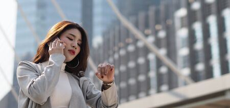 Asian business woman worried about time because she nearly late appointment with her important meeting which represent concept of work in rush hours workday and outdoor working in modern cityの写真素材