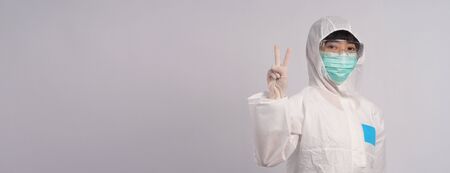 Middle aged asian nurse woman wearing PPE body suit or personal protective equipment which for use in pandemic virus infected situation with medical mask, gloves, gogglesの写真素材