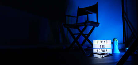 Behind the scenes letterboard text on Lightbox or Cinema Light box. Movie clapperboard megaphone and director chair beside. Background LED color change. static camera in video production studio.の写真素材