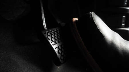 Close up the foot pressing foot pedal of a car to drive. Accelerator and brake pedal in a car. Driver driving the car by pushing accelerator and break pedals of the car. inside vehicle. control pedal.の写真素材