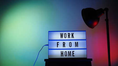 Work from home light box in studio. WFH Text on lightbox. Represent work from home for social distancing concept during coronavirus pandemic. WFH message on light board COVID 19 quarantine situation.の写真素材