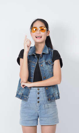 Asian Young woman gesture posing on white background. represent cheerful and confident. Showing gestures such as mini heart Okay Thumb up or point out. Happy amazed excited and surprised Jacket jeans.の写真素材