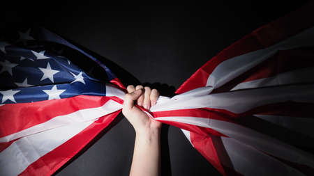 American flag and Military hat or bag. Top view angle. Soldier hat or helmet with national american flag on black background. Represent military concept by camouflage object and USA nation flag.の写真素材