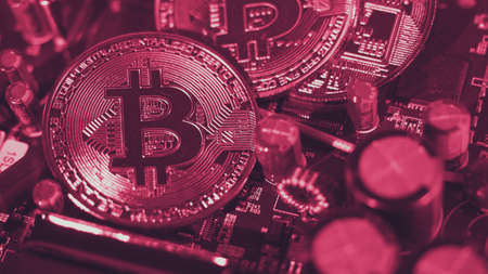 Bitcoin and semiconductor. Represent mining in Cryptocurrency cause global warming. Bitcoins on CPU board. Close-up Bitcoin with blue and pink light. circuit board with coin. Online asset concept.の写真素材