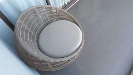 Outdoor beach chair on the hotel room balcony or terrace which made from natural wood called rattan and brown color round shape and look luxury for relaxing or sleeping or for party.の写真素材