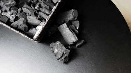 Black Charcoal on black textured floor. charcoal black carbon reesidue produced by strongly heating...