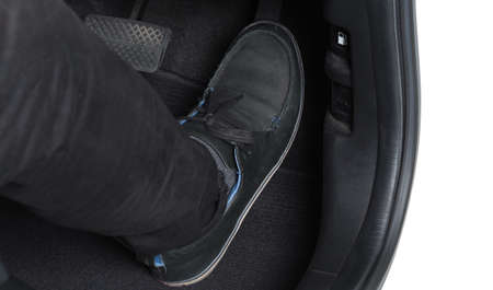 Man foot and accelerator and brake pedal inside the car or vehicle and copy space which black color leather shoe stepped on it for speed up or control automobile pace power. Automobile Driving concept.の写真素材