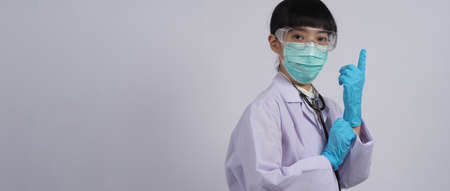 Wearing gloves. Asian doctor wear blue rubber nitrile hands glove. Doc with a mask putting on gloves. isolated white background copy space. Health care protection coronovirus pandemic concept.の写真素材