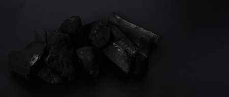 Wood charcoal. Black Charcoal on black textured floor. Used for cooking grill or other industries. Natural wood charcoal. Black carbon reesidue produced by strongly heating wood. for traditional BBQの写真素材