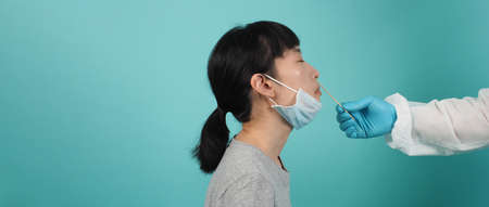 RT PCR test. woman with Covid 19 swab test. Coronavirus test during epidemic. Medic taking sample for virus testing. blue green background. Doctor in PPE suit swab testing. Virus Rapid Antigen Test.の写真素材