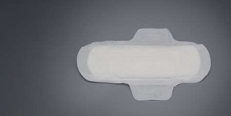 Napkin sanitary. Soft and comfort sanitary napkin pad and grey background. White top sheet. Studio shot isolated. Cloth pads for menstruation. Wing type for night. Quick absorber. cotton soft feeling.の写真素材