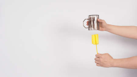 Clean and wash dish concept. Man hand washing drink glass on white background. Used drinking glass...