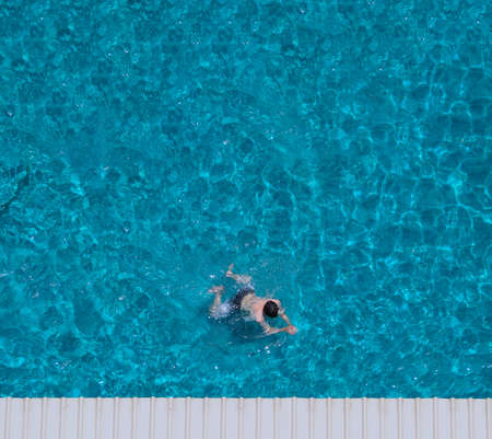 Swimming pool blue water in summer top view angle. Aerial view images of swimming pool in a sunny day which suitable for sport or relax on vacation time or workout for burn some calories in holiday.の写真素材
