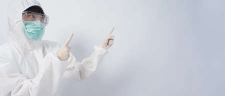 Doctor in PPE suit wearing white medical rubber gloves and clear goggles and green N95 face mask to protect pandemic Coronavirus. gesture make hand sign. Represent victory win over virus. Isolated.の写真素材