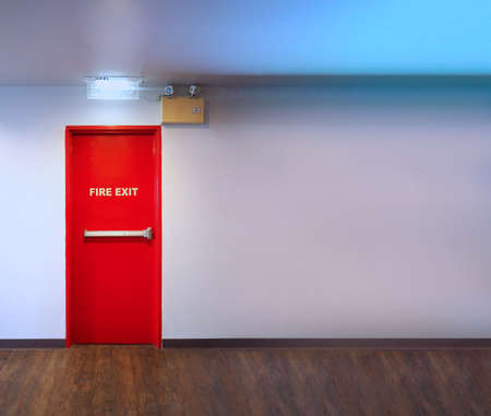 Fire exit door. Fire exit emergency door red color metal material with alarm and emergency light and fire extinguish equipment on building wall for safety protection. Doors for escape conflagration.の写真素材