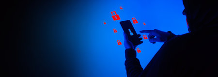 Digital security Concept. Anonymous hacker with mask holding smartphone hacked. Personal and Cyber data security in mobile phone stolen by man in mask. Represent digital privacy protection concept.の写真素材