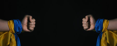Russian flag and Ukrainian flag on a black background. Russian flag and Ukraine flag in hands...