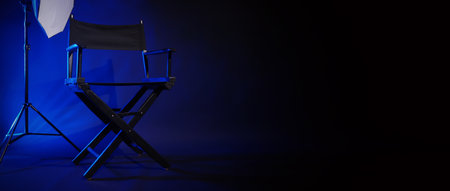 Director chair with cinema lightbox sign Director text on it and clapperboard megaphone and black background studio. Director seat on video production or filming set used in film industry. Real no 3Dの写真素材