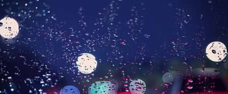 Driving in raining. Rain on car windshield or car window in rainy season and blurry traffic road in background. Rain drops on car mirror. Road in rain. Drizzle raining decreases driving visibility.の写真素材