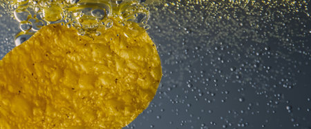 Deep fried potato chips under golden oil water. Frying rounded potatoes chip with hot boiling oil bubbles. Fast food and snack. Underwater cooking oily french fries or potatos chips in oils backgroundの写真素材