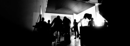Silhouette images of making of or behind the scenes of video production which produced in the film studio that include all pro light and camera equipment and professional film crew with movie directorの写真素材