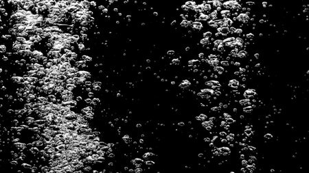 Soda water bubbles splashing underwater against black background. Soda liquid texture that fizzing and floating up to surface like a explosion in under water for refreshing carbonate drink concept.の写真素材