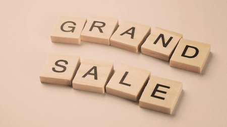 Word of Grand Sale. Text written by wood toy or wood cubes on white paper background with texture. Top view of wooden english alphabet arranging to words. Close up of photo letter design wood toys.の写真素材